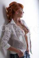 Hot red-haired woman posing in unbuttoned blouse