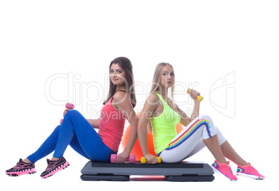 Pretty sporty girls posing with gymnastic items