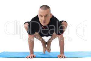 Handsome middle aged man doing yoga in studio