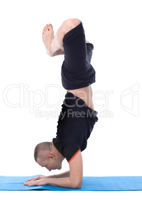 Image of calm man doing yoga handstand