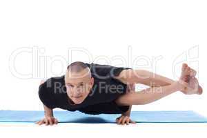 Smiling flexible man posing in difficult yoga pose