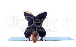 Concentrated man doing yoga in studio