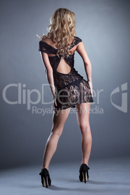Slender curly blonde posing in black lace negligee