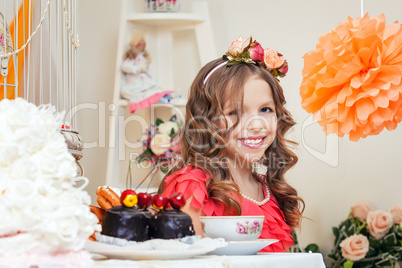 Image of smiling elegant young girl drinking tea