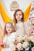 Charming little sisters posing in vintage interior