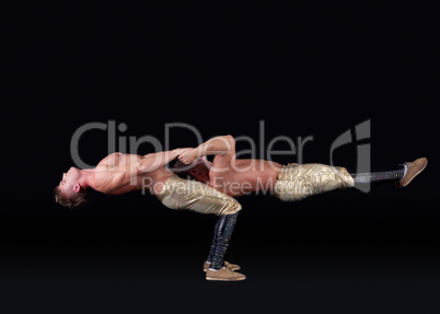 Two seminude acrobats posing keeping balance