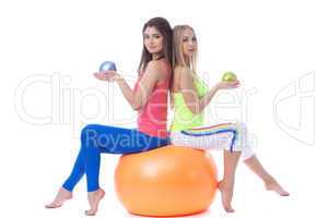 Attractive sportswomen sitting on gymnastic ball