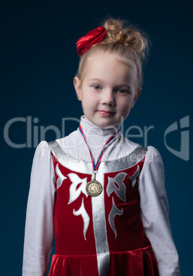 Pretty little sporty girl posing with medal