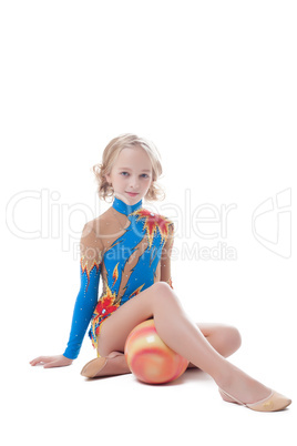 Stately little gymnast sitting in studio with ball