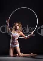 Curly slim artistic gymnast posing with hoop