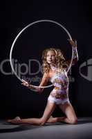 Flexible young girl posing with gymnastic hoop