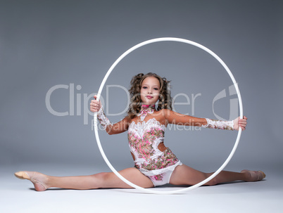 Adorable young artistic gymnast sitting on split