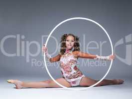 Adorable young artistic gymnast sitting on split