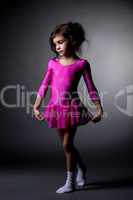 Adorable little gymnast posing in pink dress