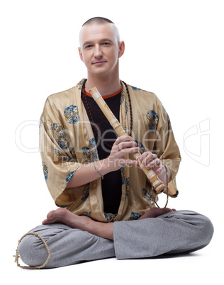 Yoga guru playing flute, isolated on white