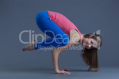 Attractive woman performing difficult yoga pose
