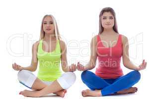Pair of pretty young girls meditates in studio