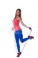Smiling muscular girl posing with skipping rope