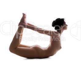 Flexible naked woman doing exercises in studio