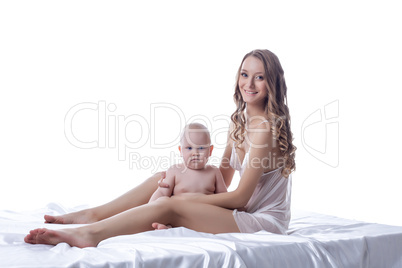 Smiling lovely model posing with her son in studio