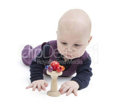 baby looking at wooden toy