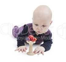 baby looking at wooden toy