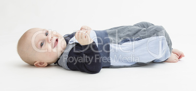 smiling toddler laying on his back