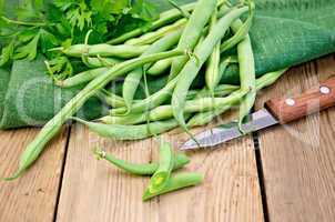 Beans green on the board with a knife