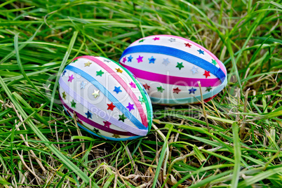 Easter eggs with ribbons and stars on grass
