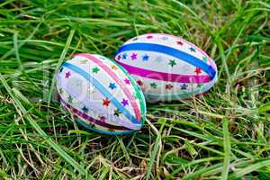 Easter eggs with ribbons and stars on grass