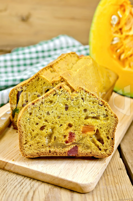 Fruitcake pumpkin with candied fruit and knife on board