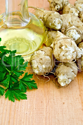 Jerusalem artichokes with carafe of oil on board