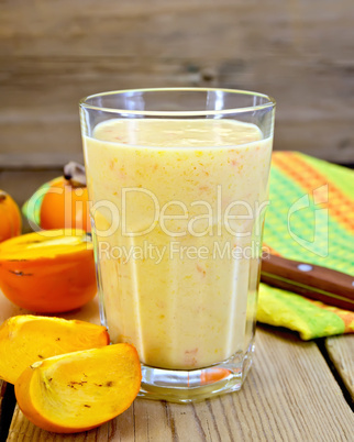 milkshake with persimmons in glass on board