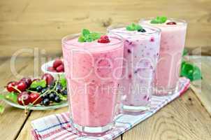 milkshakes with berries in glass on board