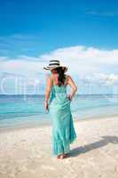 girl walking along a tropical beach in the maldives.