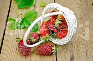 Strawberry poured out of basket on board