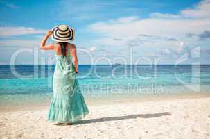 girl walking along a tropical beach in the maldives.