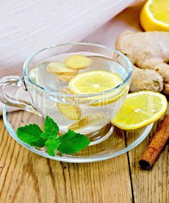 Tea ginger with lemon in a cup on board