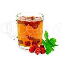 Tea with raspberry and leaf in glass mug