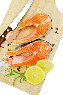 Trout with lemon and knife on plank