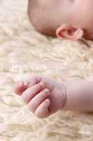 Hand of a small baby lying on a blanket