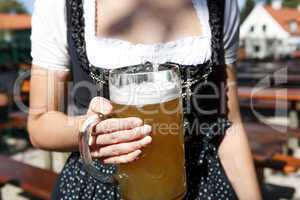 young woman holding a beer mug in the beer garden