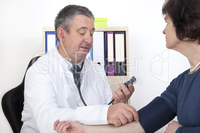 experienced doctor measures blood pressure