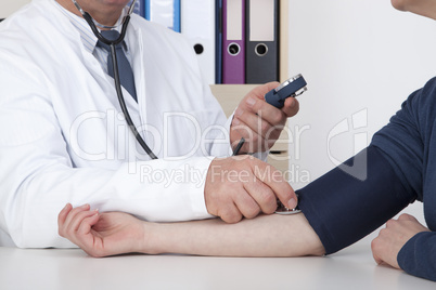 experienced doctor measures blood pressure