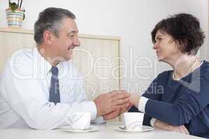 man comforting woman over a cup coffee