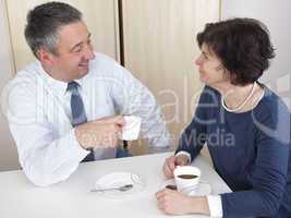 man and woman chat over a cup of coffee