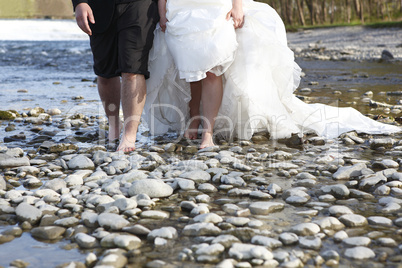 Bride and groom walking through water