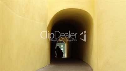 silhouettes walking through dark tunnel