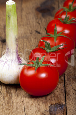 tomaten in einer reihe mit einer knoblauchknolle