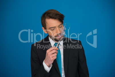 businessman with e-cigarette wearing suit and tie on blue